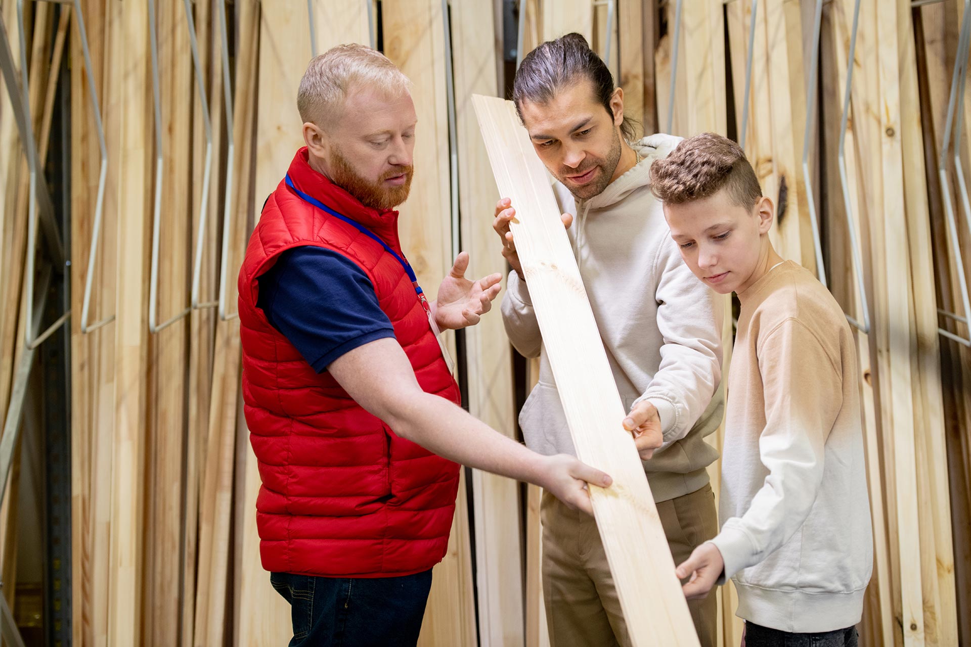 Mann berär Vater und Sohn für das richtige Holz im Fachmarkt