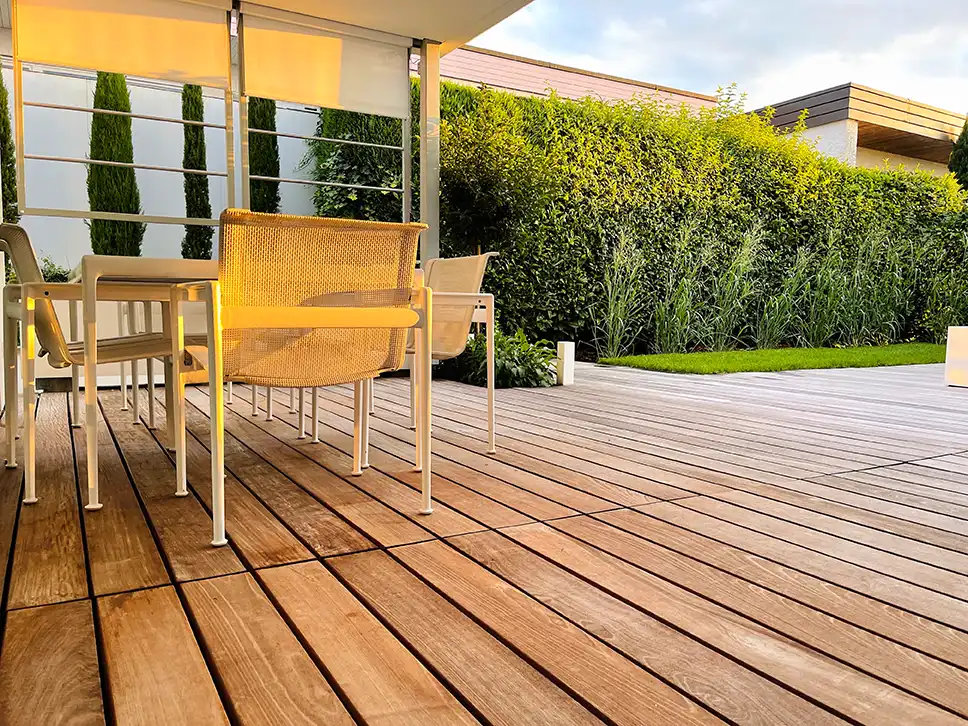 Terrasse mit glatten Holzdielen und gelben Gartenstühlen